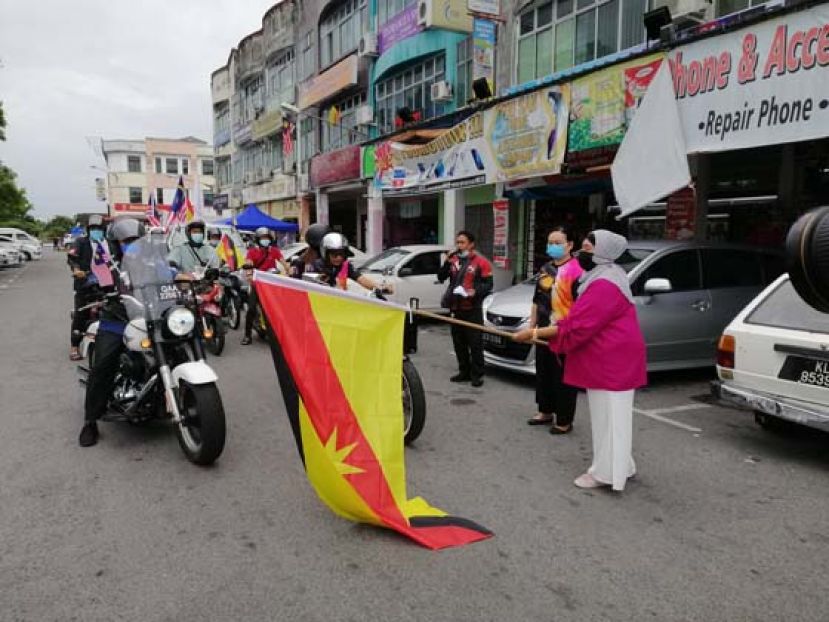 国家社区推动组织砂拉越分会主席诺哈尼（右一）主持古晋、诗巫远征车队挥旗礼。