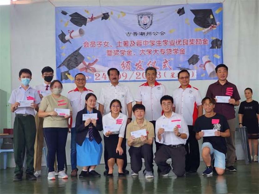 （档案图片）古晋潮州公会于去年举办的2023年度会员子女学业优良奖励金颁发仪式上的部分领奖者与该会领导及贵宾合影。