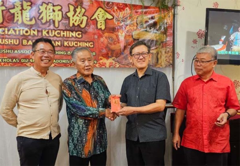 薛华东（右2）代表古晋武术龙狮协会送红仪予顾问拿督杨昆贤。左为该协会会长刘添闹；右是署理会长郑李金春。