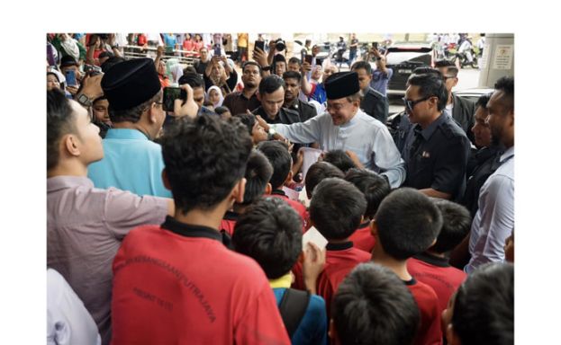 首相安华进行周五祈祷后，与一批学生互动。