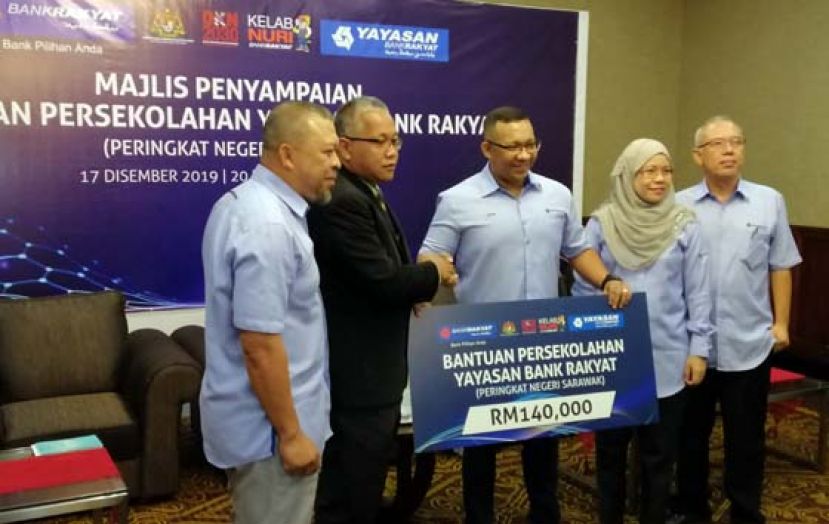 人民银行市场与通讯主任尼扎沙尼（右三）移交银行基金会的学校援助金予砂教育局局长阿兹哈阿末（左二）。