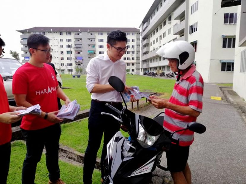 浮罗岸区州议员黄庆伟（白衣）派发骨痛热症防范传单，并详细的解说。