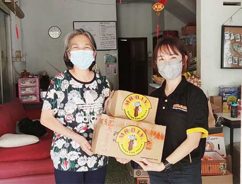 Belinda Chew [左], Pertubuhan Kanak - Kanak Angel 代表从 MR. D.I.Y. 团队Jyvin Khor [右]手上接过鼻腔自测套件。MR. D.I.Y.将捐赠超过  1,000个检测试剂盒予全国 23 家慈善机构。