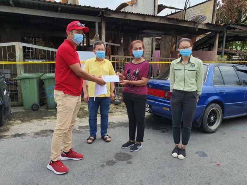 沈桂贤（左二）见证莫哈末阿斯曼移交安排灾民暂时住在其他组屋的通知书。