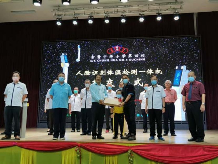 学生家长陈梦仁（前排右3）移交人脸识别体温检测机予古晋中华小学校董会主席拿督王长福（前排左3），右1及左2分别是四小校长贝荣栋和校董会署理主席蔡文铎律师。