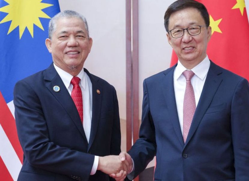 副首相法迪拉(左)与中国国家副主席韩正握手。