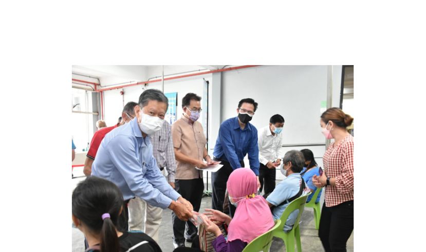 会长拿督陈日枝（左一）移交派发红包予盲人训练中心成员。