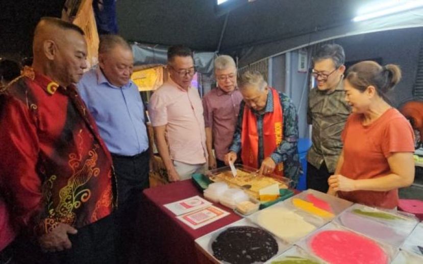  主宾拿督杨昆贤（右3）在古晋缤纷文化庆中秋庆典即兴来制作食品。右2是庆典顾问薛华东、左为庆典主席甲必丹林传政等人。
