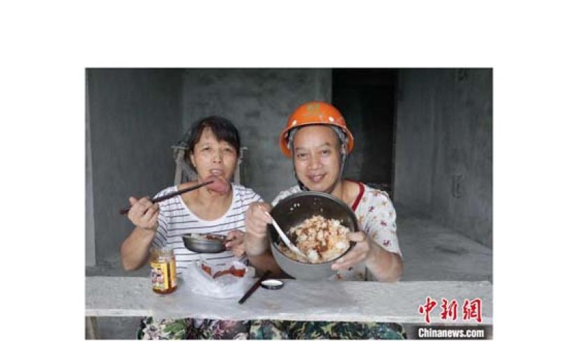 川哥和老婆在工地上吃饭。