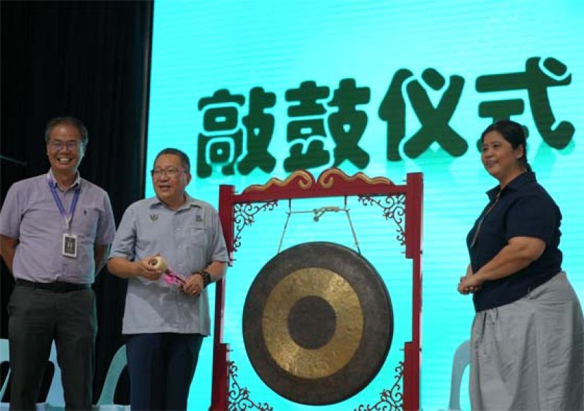 古晋南市市长拿督黄鸿圣（中）为比赛活动主持鸣锣仪式。左为李志鹏校长，右是联课活动处萧俊琪主任。
