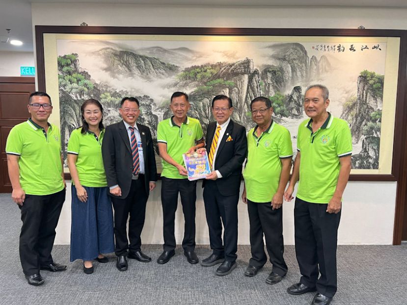 古晋广惠肇公会署理主席张锦兴（中）赠送该会160周年纪念特刊并移交邀请函予拿督斯里李景胜。