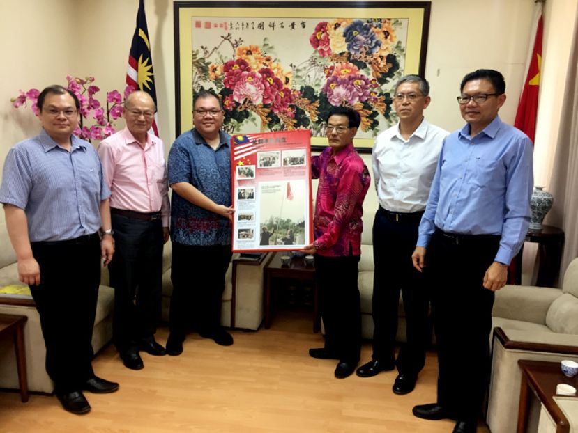 拿督黄国辉（左三）把图集移交予程广中（右三）总领事时摄。右起为王志强及张阳副总领事。左起则是一陈朝忠及李福安。