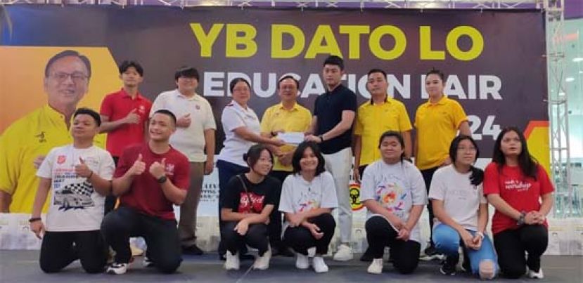LYA Construction有限公司总监杨立锋(后排右三）在砂人联党峇都吉当支部主席兼峇都吉当区州议员拿督罗克强见证下，移交捐款古晋救世军儿童之家主管黄美怡；后排右起为筹委会主席张凤云和砂人联党峇都吉當支部青年团团长庄育华。