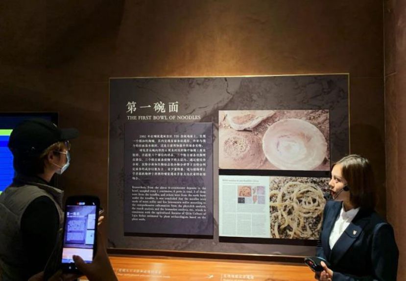 参观者在青海省民和县喇家遗址博物馆内听讲解员介绍距今已有4000多年历史的&ldquo;第一碗面&rdquo;。