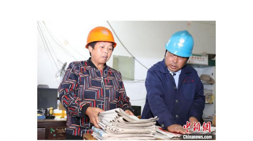 夫妻俩正在整理、分发报纸。