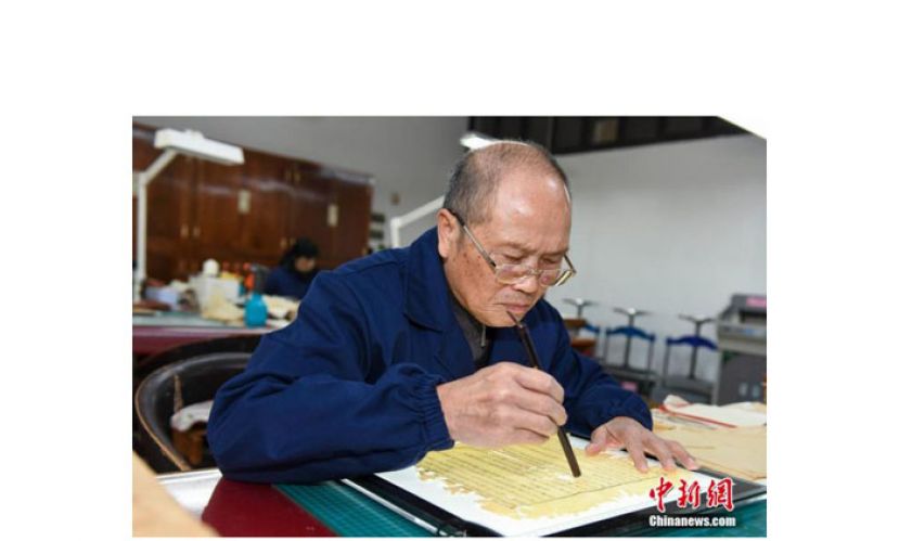 师玉祥用毛笔沾清水打湿古籍，方便修补。