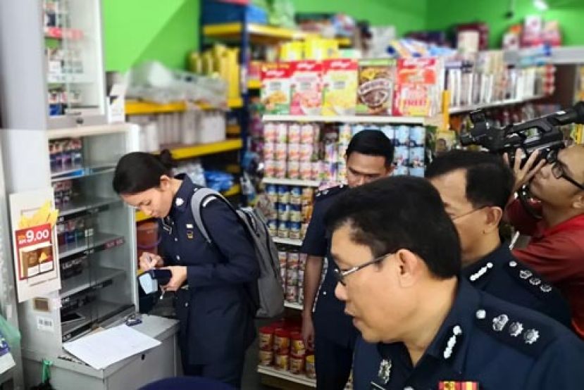 关税局执法官员使用检测仪器检查香烟的税章。