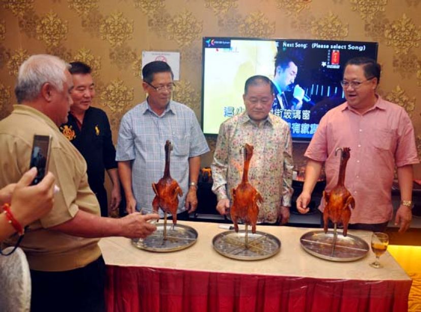  拿督斯里刘为强太平局绅（右二）在嘉宾的陪同下，为烤鸡点火。