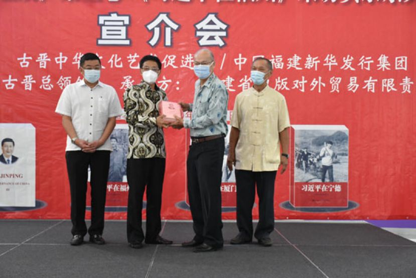 中国驻古晋总领事程广中（左二）将《习近平谈治国理政》（第三卷）书籍移交予拿督黄国辉的代表李福安（右二）。左一为晋汉连省华总会长拿督黄良杰，右一为古晋中华文化艺术促进会会长陈华敏。