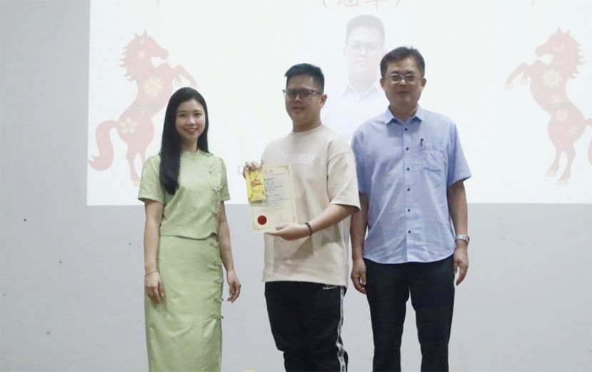 颁发奖项予 硬笔书法比赛 高中组冠军詹兴鸿 ，左为校长赖淑珍，右为巴达旺市议会主席陈开。