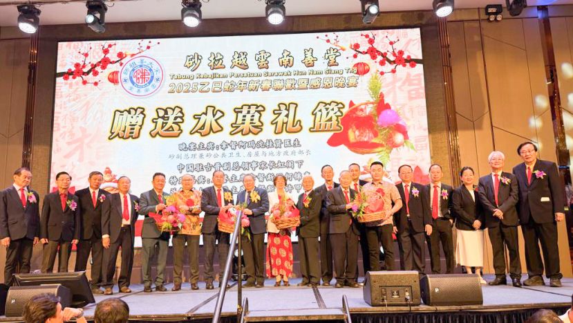 砂拉越云南善堂主席郑文新（左七）赠送水果礼篮予拿督阿玛沈桂贤的代表拿督黄鸿圣（左八）、筹委会主席甲必丹刘天金（左五）赠送水果礼篮予拿督斯里许甲明代表许宝通（左六）、副主席符气元（右十）赠送水果礼篮予中国驻古晋副总领事宋长虹（右十一）、副主席钟名宝（右八）赠送水果礼篮予名誉主席拿督斯里何锦喜代表拿督郑天鸿（右六）。 左起为秘书张南华、副医药李益石副主席刘顺荣、副主席郑瑞福。右一起为副国英文书郑文发、福利主任本固鲁田新华、副秘书赖小冰、副中文书郭津靖、副财政林瑞釗、法律顾问兼国英文书郭鎔华（左十三）与副主席郭兴开（左十一）。