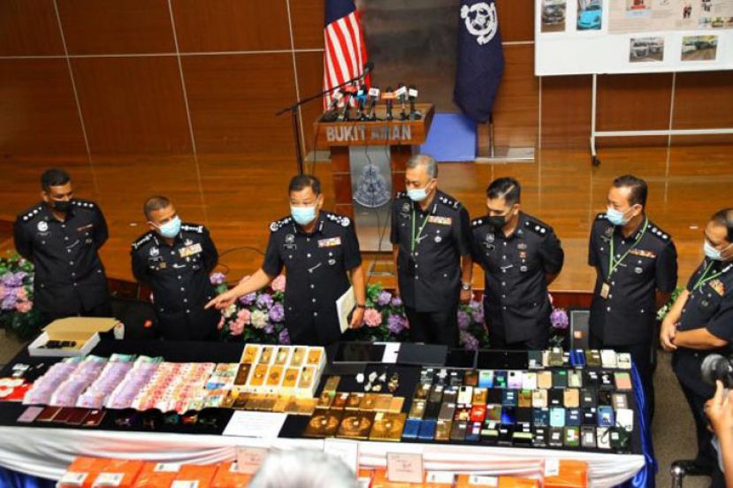 丹斯里阿都哈密（左三）展示瓦解廖顺喜为首的犯罪集团所起获数的物品。