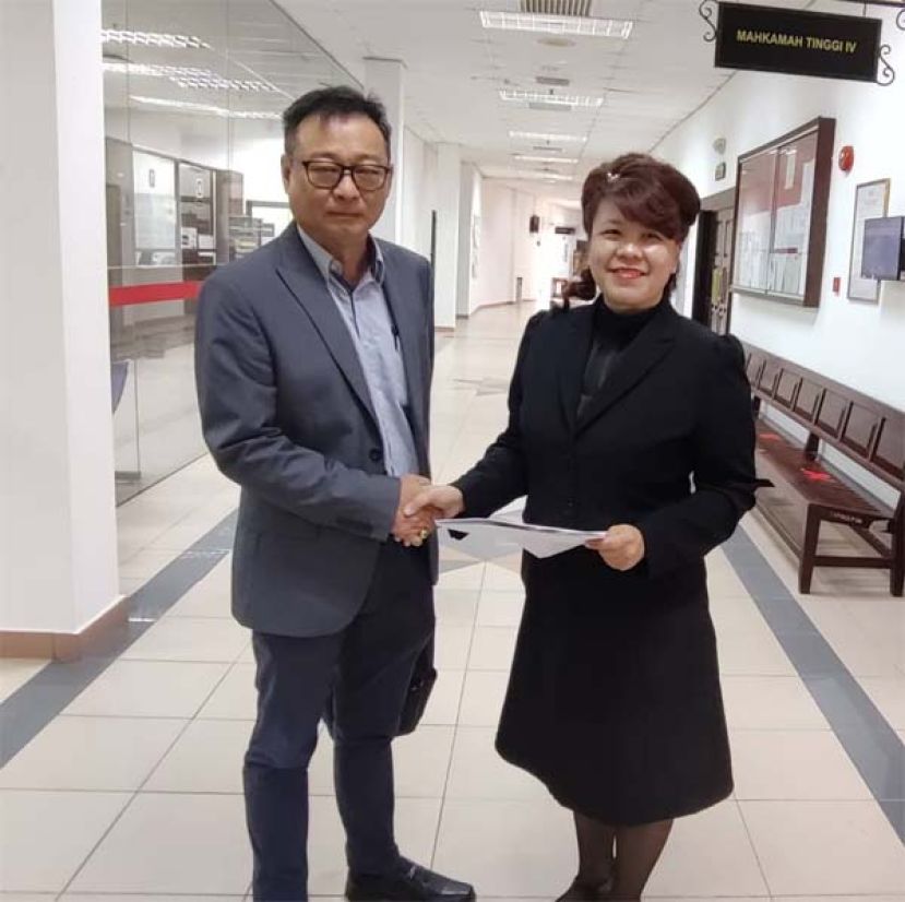 杨薇讳（右）和拿督沈坚石握手和解。