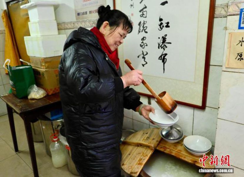 南昌&ldquo;一元水酒店&rdquo;内，店主王细英在为顾客打酒。