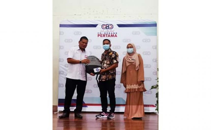 大马第一合作社银行（古晋）首席执行员莫哈奴（左）移交捐献予受惠者，右为砂教育局官员哈妮法。