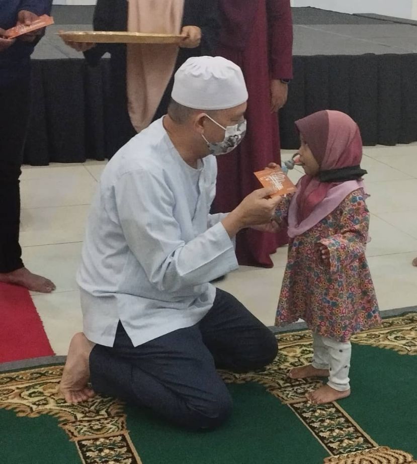 在仪式上，工程部部长拿督斯里化迪拉友索和小女孩交谈时摄。