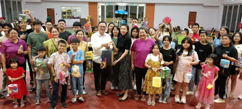 古晋爱心书协会秘书田素瑛赠送月饼予巴都吉当区议员罗克强（中）、古晋爱心书协会创办人兼主席吕晗韵（右五），第二排左四为砂总理署政治秘书许德婉。