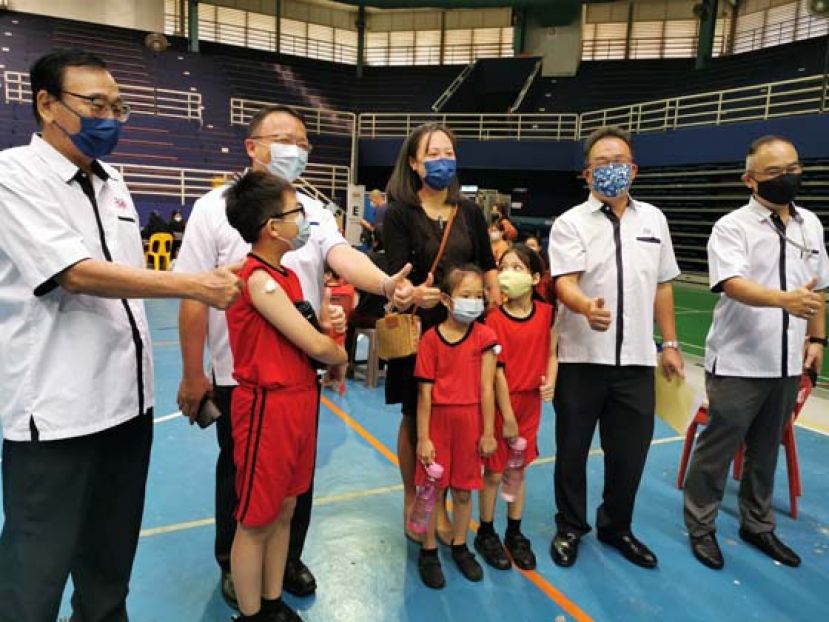 古晋中华小学校董会主席拿督蔡文铎（后左2）率领校董前往巡视三小学生接种疫苗情况时。