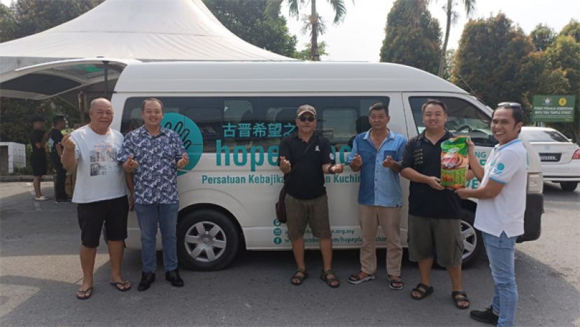 古晋三哩中元普渡盂兰盆节胜会筹委们移交物资和干粮给予希望之家的代表。