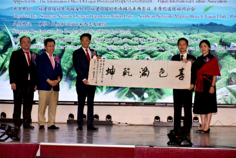 福建省对外文化交流协会副会长吕宏波（右二）及福建省对外文化交流协会副秘书陆传芝（右一）将墨宝赠送予中国驻古晋总领事程广中（左三）。左一起为古晋巴达旺福州公会主席甲必丹拿督刘思乐与砂拉越地方政府与房屋部部长拿督斯里沈桂贤。