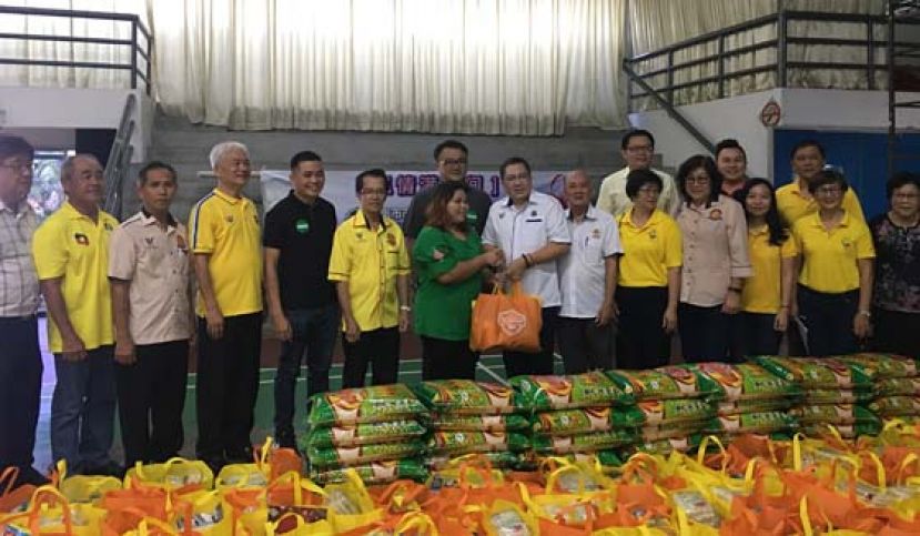 古晋南市市长拿督黄鸿圣（前排右7）移交物品予受惠代表。