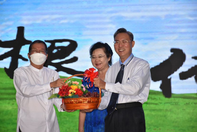 张光福与夫人刘丽玲（右一与右二）赠送礼篮予砂拉越文化研究学会会长拿督邓伦奇（左）。