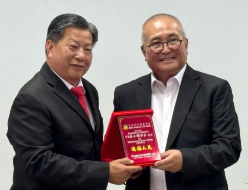 埔弈区立法议员兼美里市长俞小珊（右）由砂医总会长兼亚洲中医技职学院院长江宗兴手中接过纪念品。