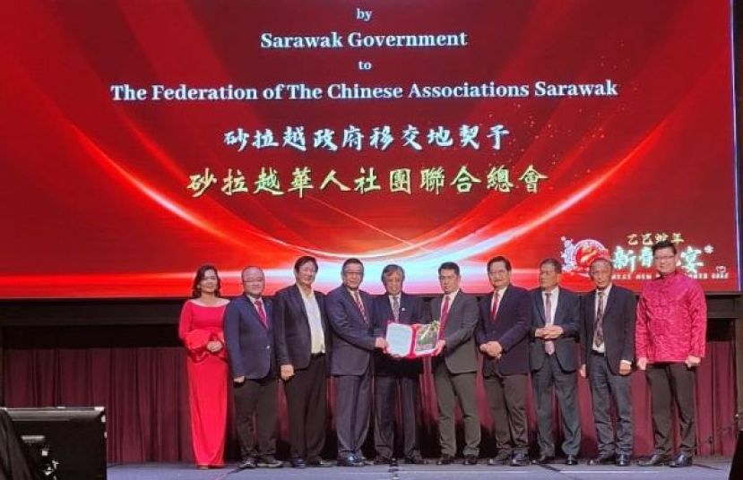 在砂总理阿邦佐（右六）的见证下，砂拉越土地与测量局局长罗斯兰布迪（右五），代表砂拉越政府移交地契予砂拉越华人社团联合总会，并由会长拿督黄良杰接收。