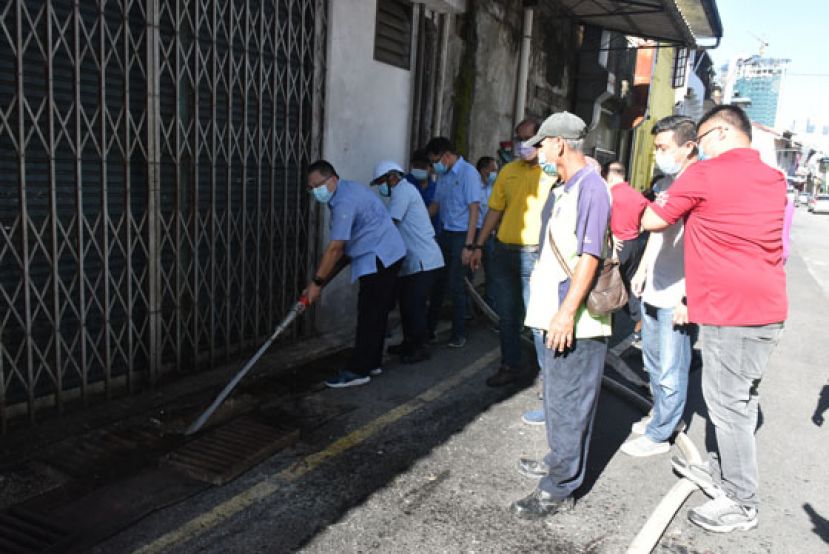 古晋南市市长拿督黄鸿圣（左一）在浮罗岸主持清洁活动。