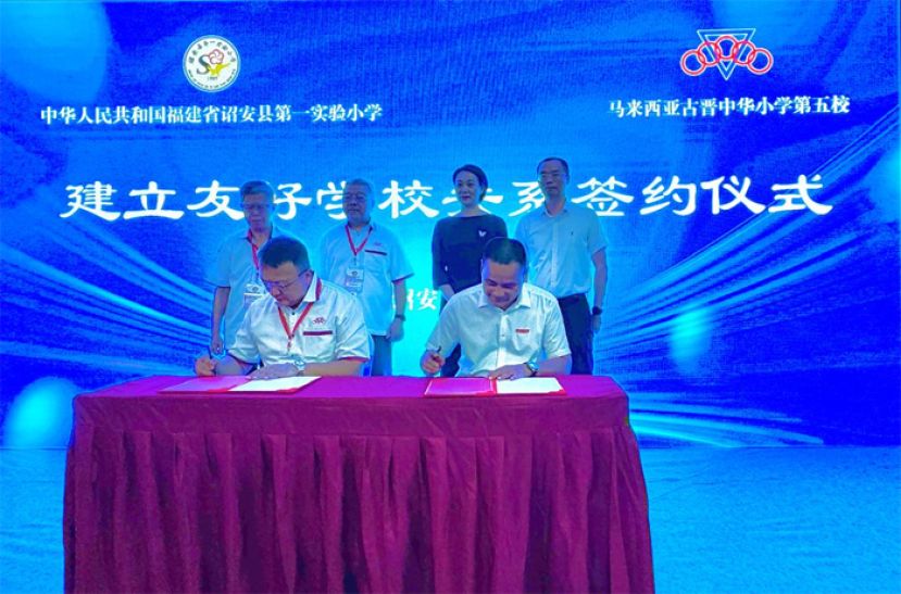 后排左起为砂拉越诏安会馆名誉主席拿督陈日枝、砂拉越诏安会馆主席许庆喜、中国诏安县委常委、统战部部长许秀彬与诏安县教育局陈曦局长见证下，古晋中华小学校董会主席拿督蔡文铎（左）与中国诏安县第一实验小学钟喜平校长（右）签署友好学校关系协议书。