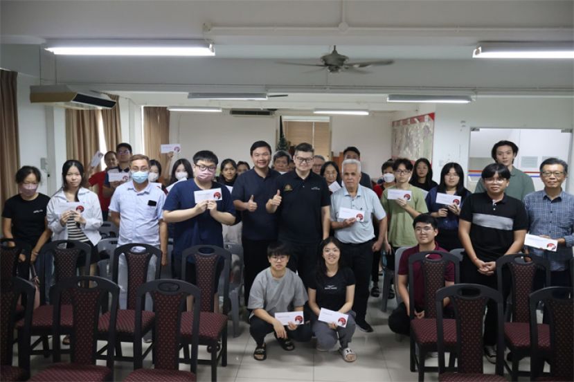 古晋市国会议员俞利文（中）与今年第二批获得其选区高等教育助学金的受惠学子合摄。
