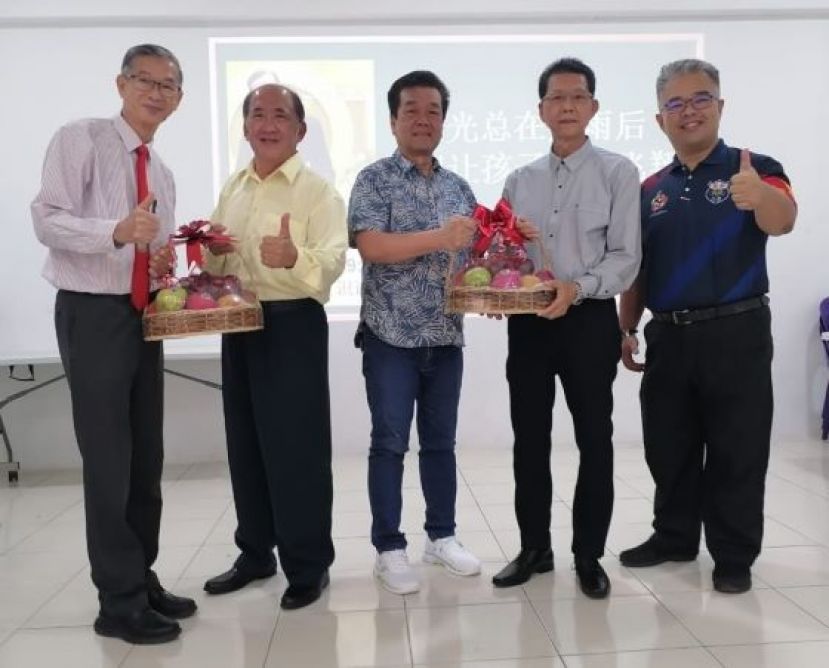砂曾丘（邱）公会会长曾瑞明（左2起）、秘书长邱熙盛分别赠水果礼蓝予赏识教育家曾桂安（左）及四中校董会副主席沈楚鹏；右是四中校长官晨阳。