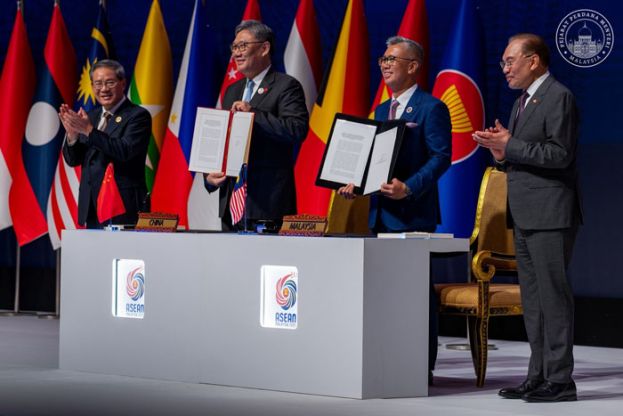 首相安华(右)与中国总理李强(左)见证王文涛和东姑扎夫鲁签署东盟—中国自由贸易协定（ACFTA）3.0。