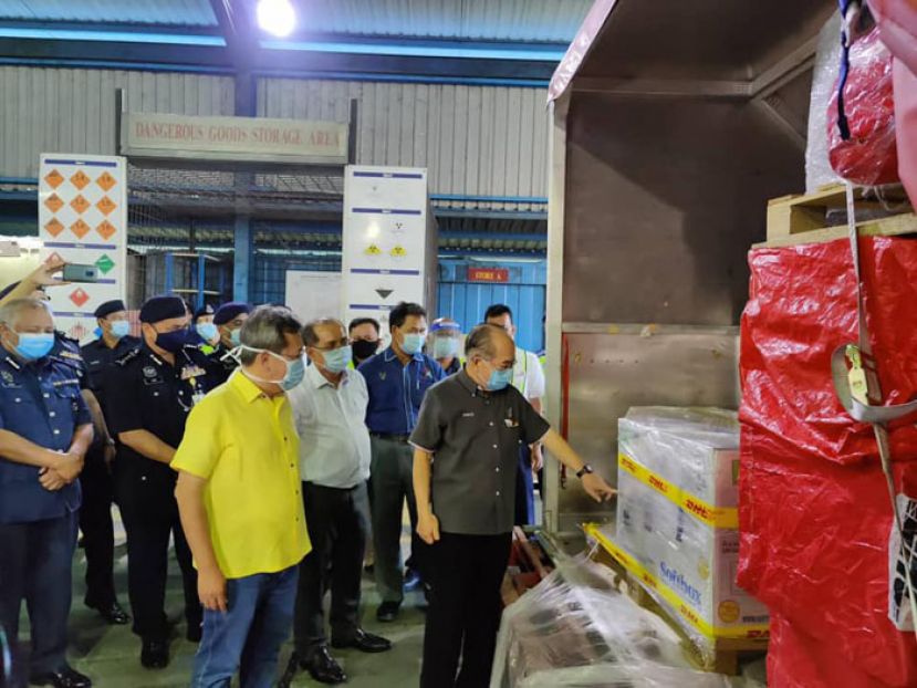 拿督阿玛道格拉斯（右一）在州务秘书拿督阿玛查勿沙米安（右三）、砂地方政府与房屋部长拿督斯里沈桂贤（右四）陪同下，象征性接收运送至砂拉越的瑞辉疫苗。