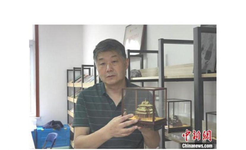 张禾展示手工制作的古建筑模型。