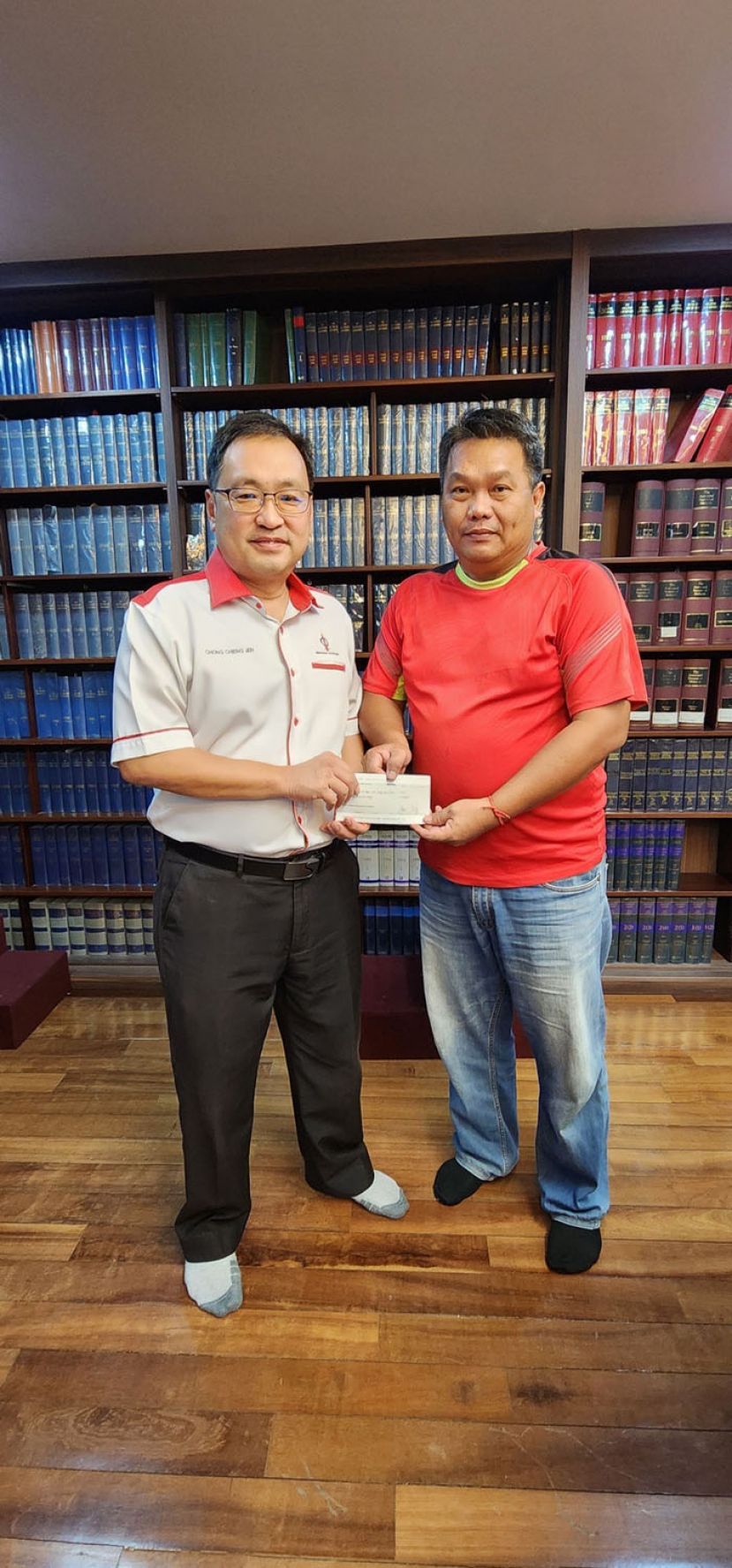 实旦宾国会议员张健仁（左）在其律师事务所移交拨款支票予西里益中公校董事会秘书邓烈强（右）以充作该校的常年活动经费之用。