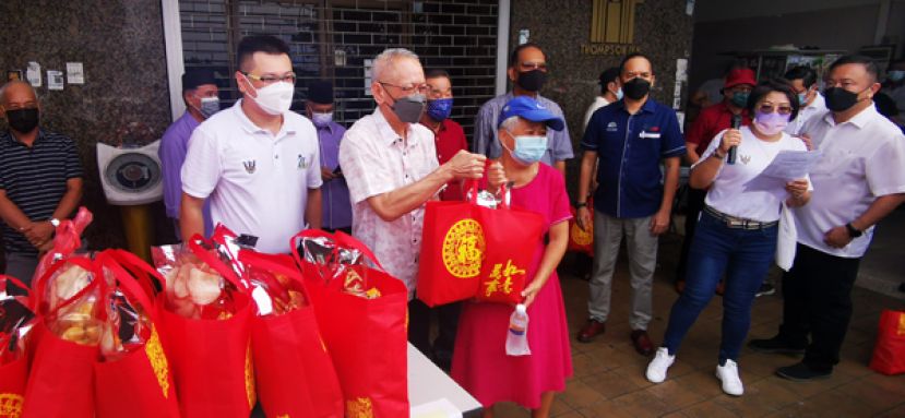 砂督区候任州议员拿督伊布拉欣巴基（中）派发新春礼品予受惠者。