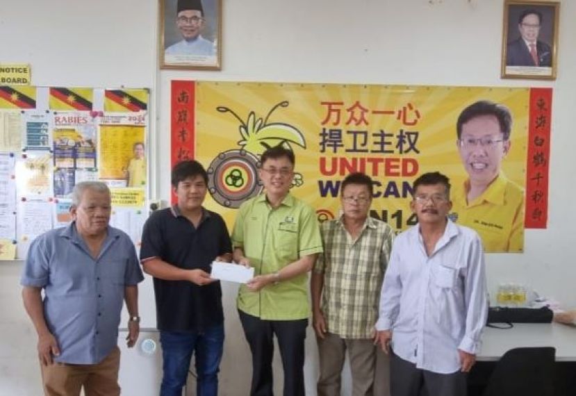 西里益福德祠筹备会主席黄锦裕（左二）将该祠申请泊油路的信涵呈交给巴达旺市议会主席陈开时影。