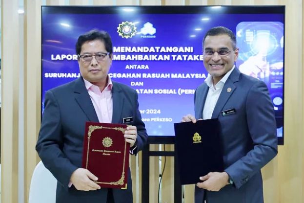 阿占峇基（左）与社险机构总执行长拿督斯里阿兹曼（右）交换签署文件。