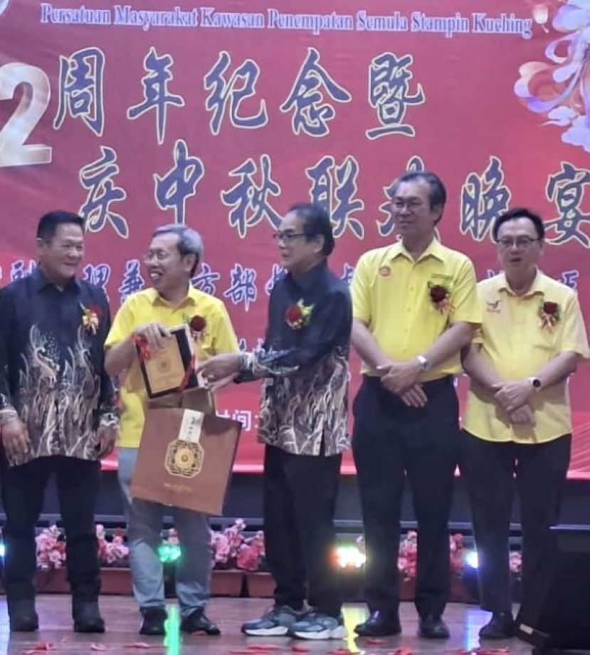 在赠送纪念品的欢聚中，砂副总理拿督阿玛沈桂贤（左二）和大会主席甲必丹温文明交谈时影。右起为峇都吉当区立法议员拿督罗克强、哥打圣淘沙区议员叶耀星以及晚宴筹委会主席涂星。